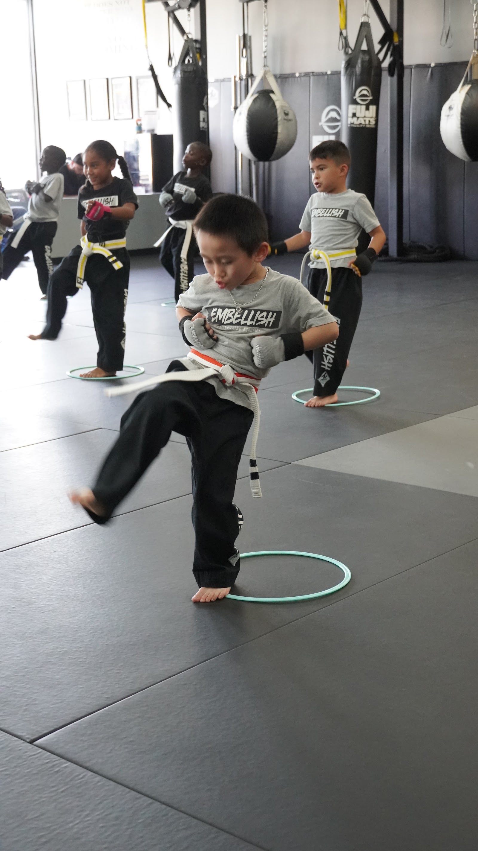 Kids martial arts class practicing kicks at Embellish Kickboxing Academy in Elk Grove.